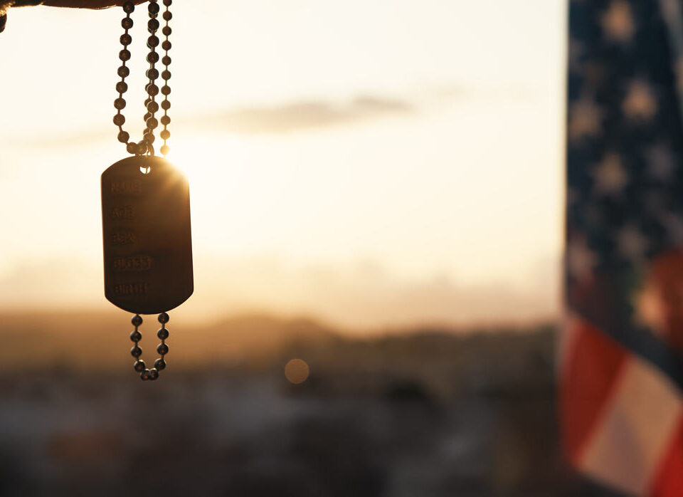 Dog tag and american flag at sunset to represent veteran counseling for anger management, PTSD, alcoholism and more